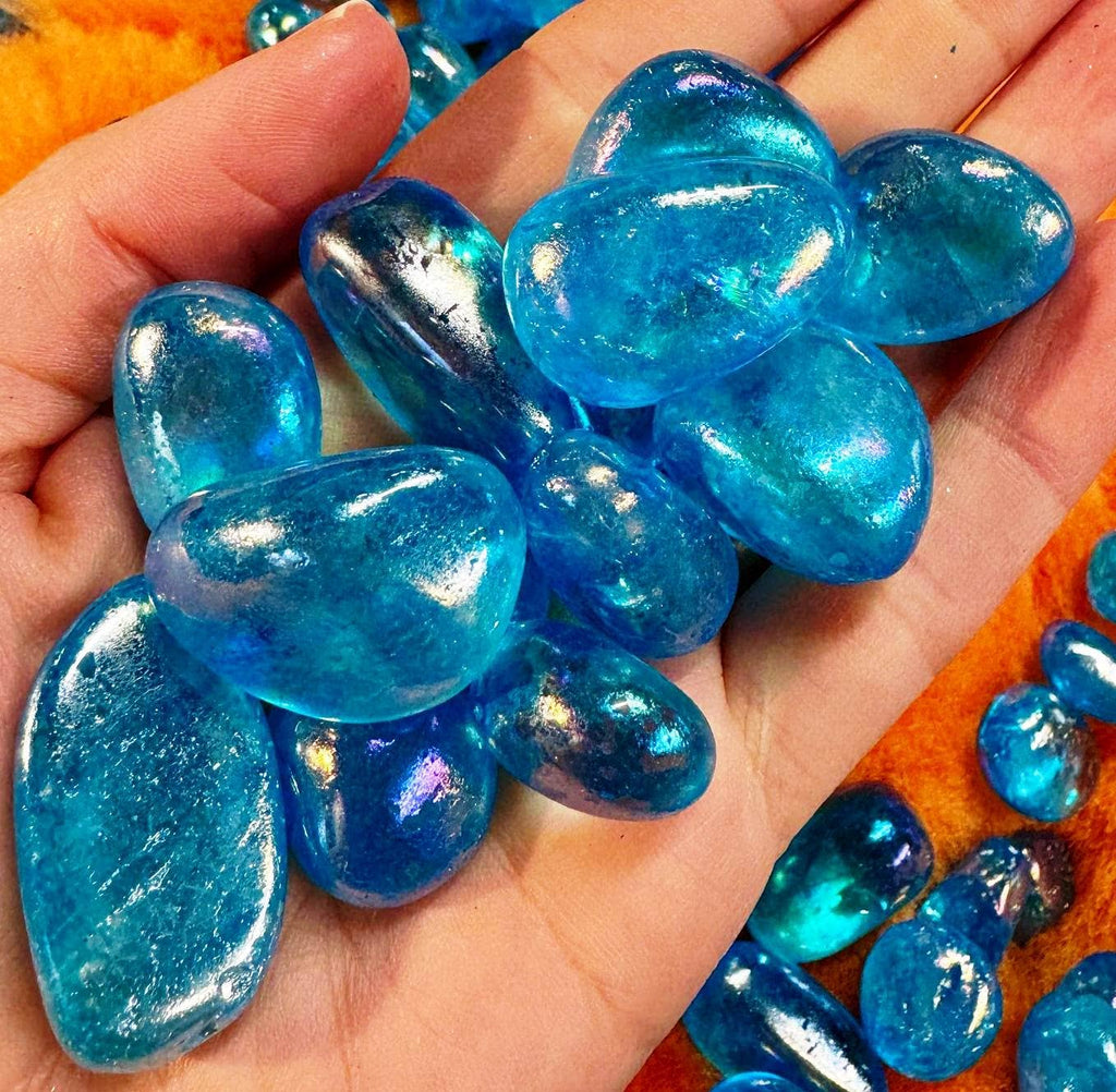 Hand holding blue glass stones with a blurred background