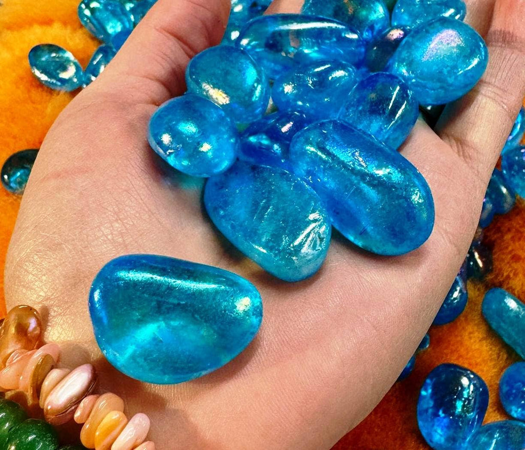 Hand holding blue glass marbles with a colorful background