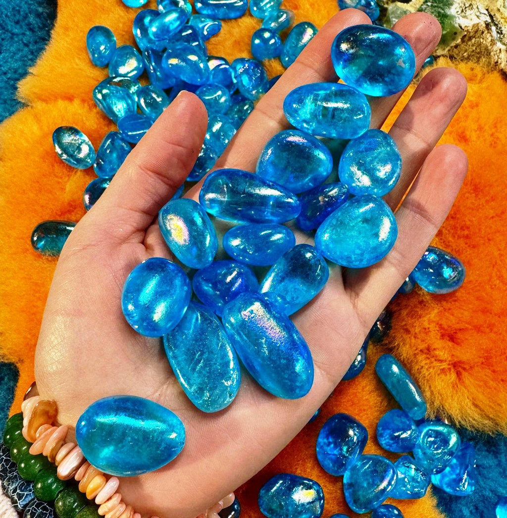 Hand holding blue gemstones with a colorful background
