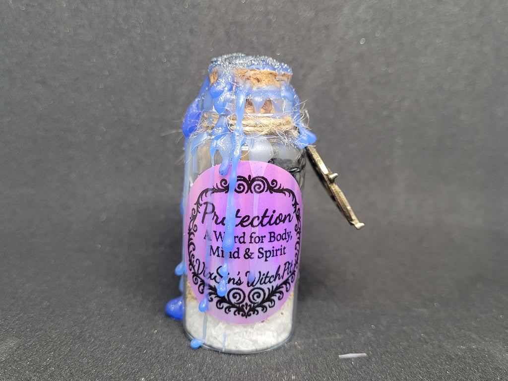 Small glass bottle with decorative elements on a gray background